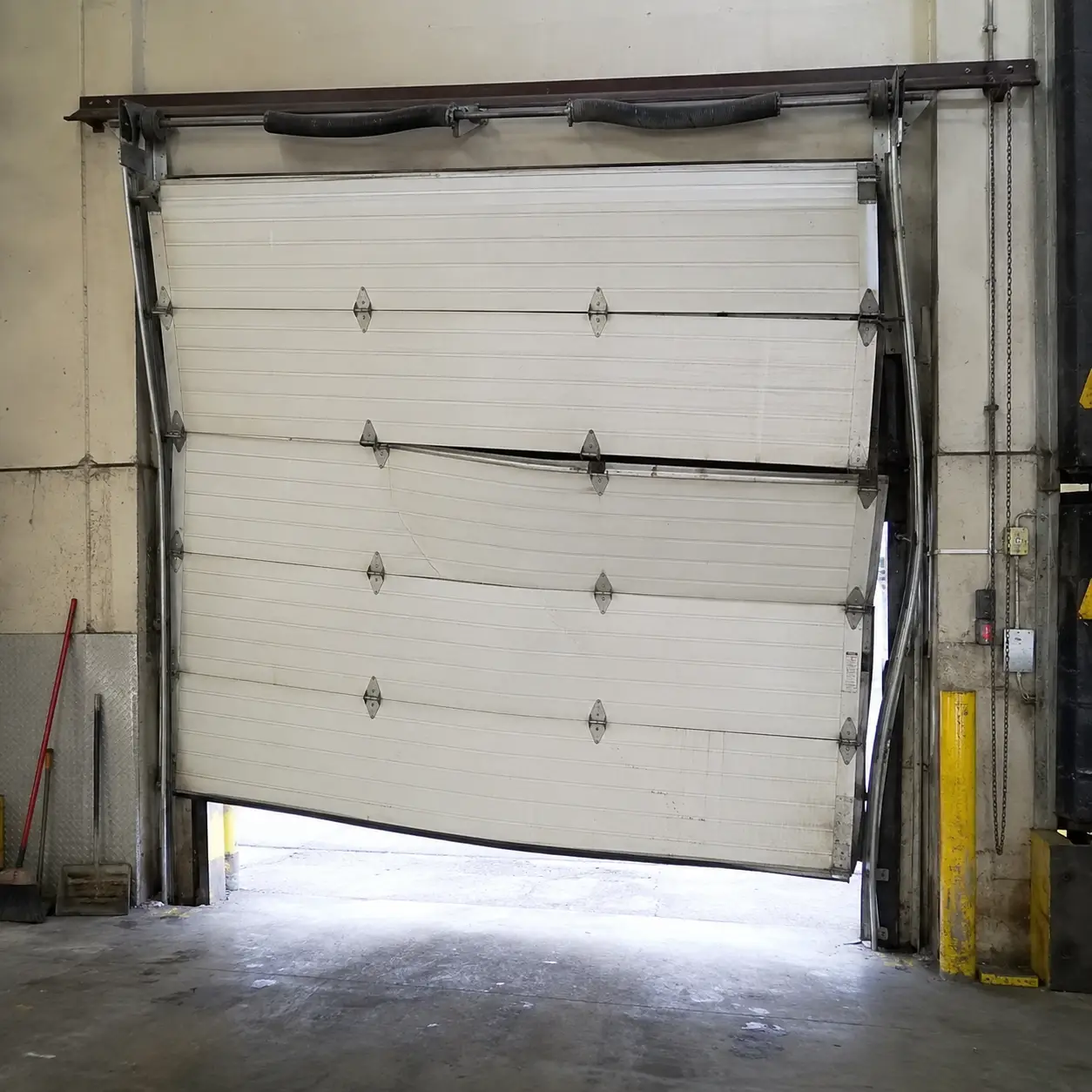 Damaged and misaligned garage door before professional repair in Noblesville Indiana
